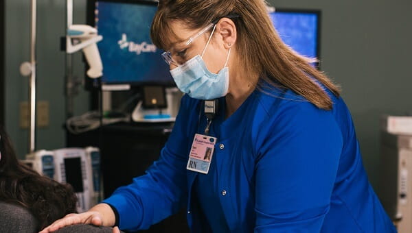 A BayCare labor and delivery nurse is helping a pregnant woman.
