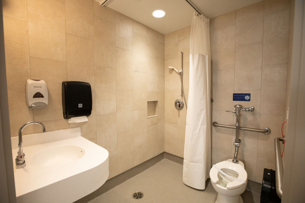 a private bathroom in a NICU room with a private toilet, sink, and standing shower