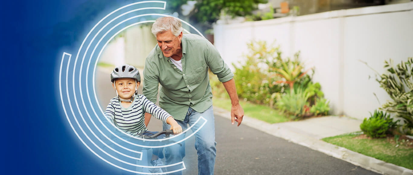 Grandfather pushing grandson on a bicycle