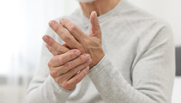 Two hands expressing discomfort from hand pain.