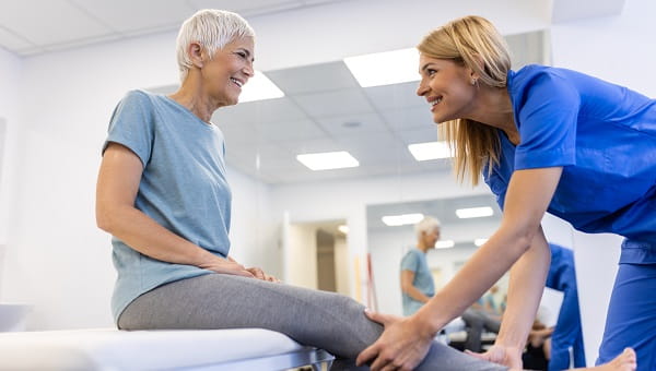 physiotherapy doctor senior patient and leg surgery physical therapy and orthopedic healing