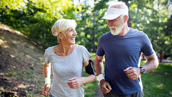 Senior couple running in a park.