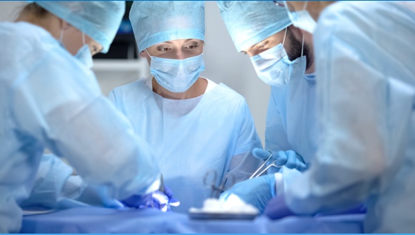 A group of four doctors practicing surgery on a patient 