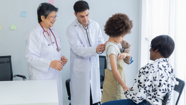 A pediatric patient being examined by two doctors