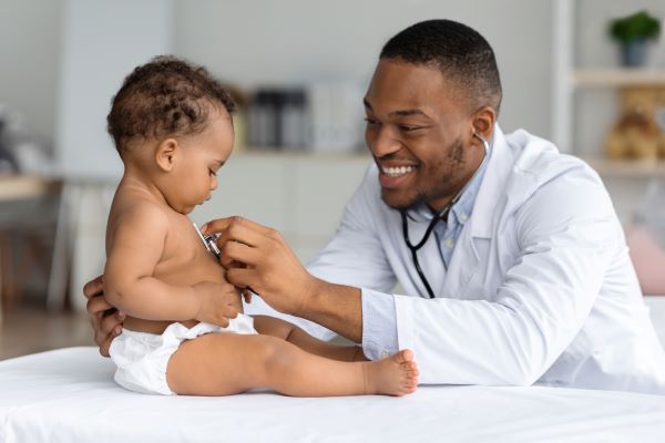 A smiling doctor examining a baby