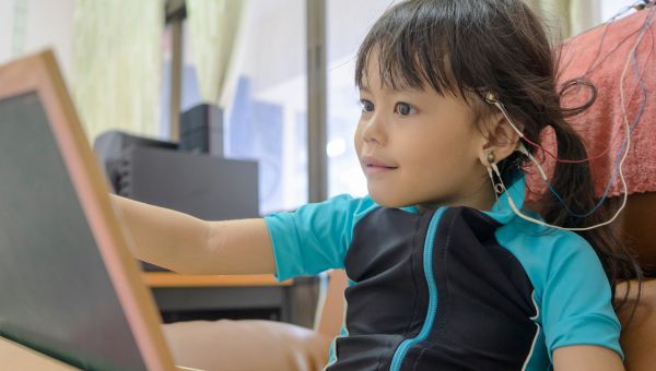 A little girl, who is a pediatric patient is connected to an EEG machine for neurodiagnostic testing