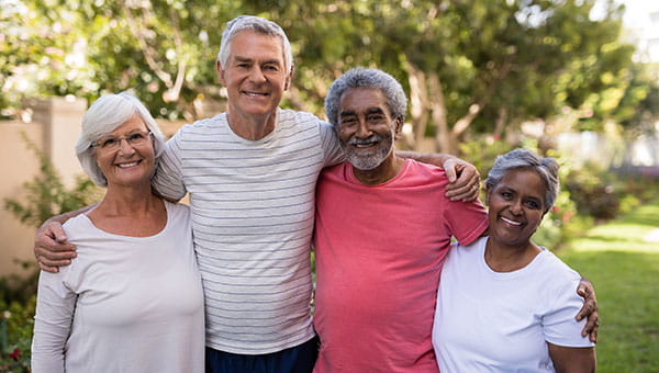 group of senior friends smiling in a park