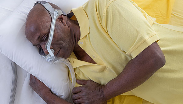 A man sleeping with a CPAP machine