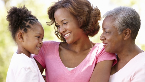 Grandma, Mom both smiling and looking at a young daughter.