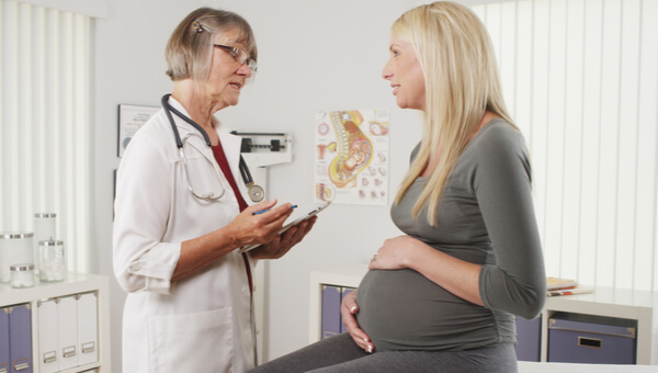 doctor explaining instructions to sitting pregnant woman