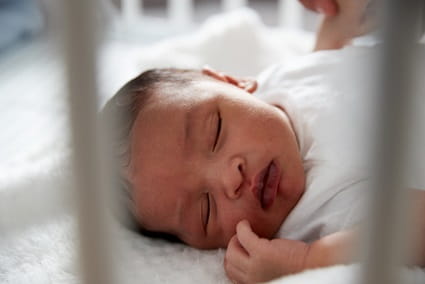 Newborn baby sleeping in a crib