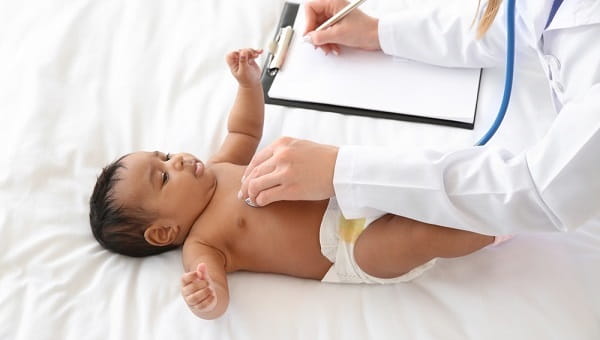 Pediatrician examining African American baby in clinic