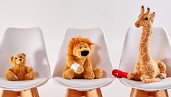 Three cute stuffed animal toys on chairs in the waiting room
