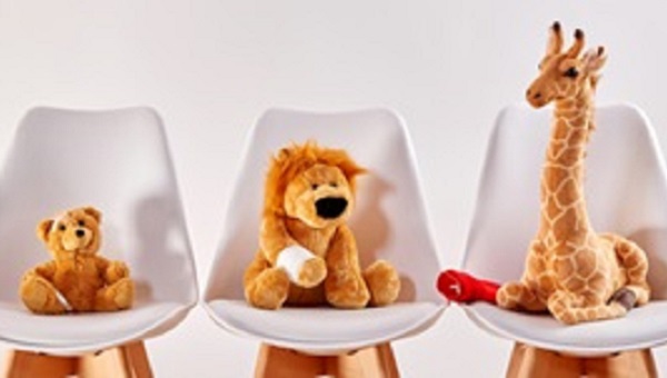 Three cute stuffed animal toys on chairs in the waiting room