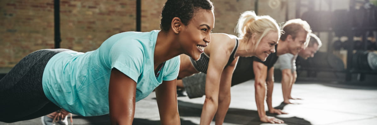 Fitness Resources at Baycare Group of active adults in a fitness setting planking together.